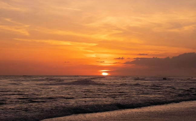 Warm Gulf sunset with gentle waves on the sand at Galveston Island
