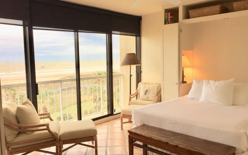 Condo bedroom with warm light and beach view
